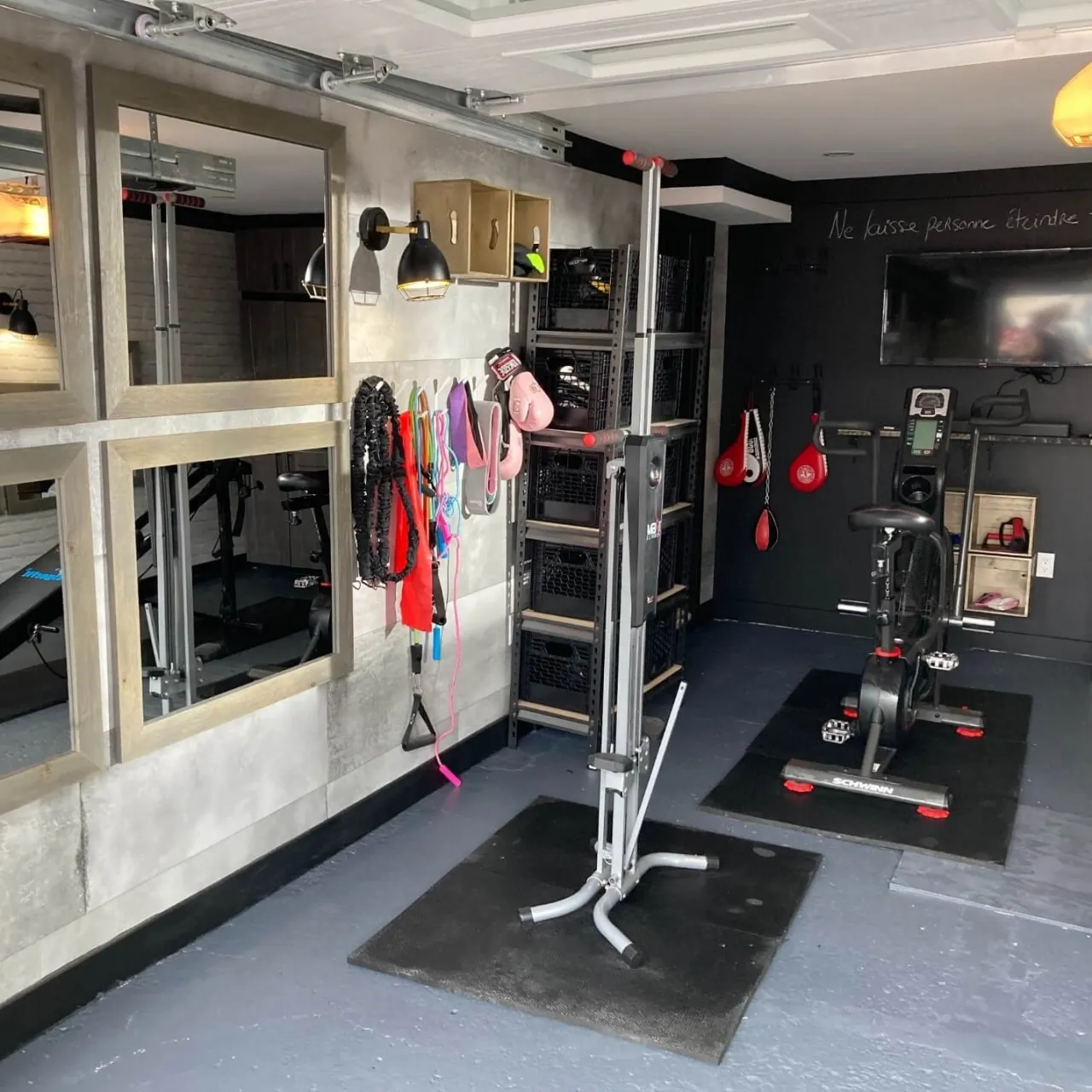 Un gym dans le garage: le plancher de béton fissuré a été réparé, peinturé et a reçu une bonne couche d’Expoxy. Miroirs, espacements de rangement. Tout y est!